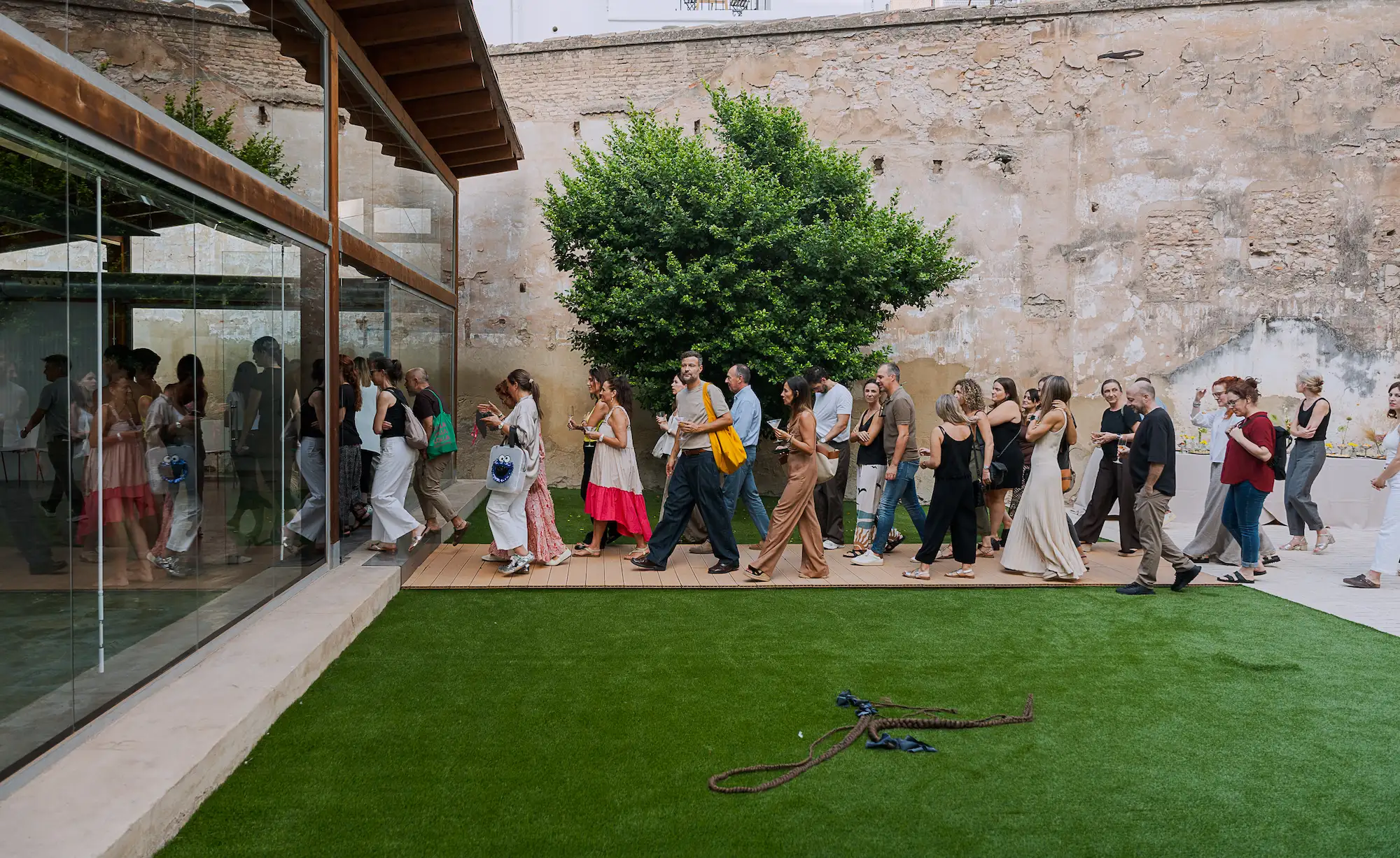 Gente en el jardín entrando a la acristalada